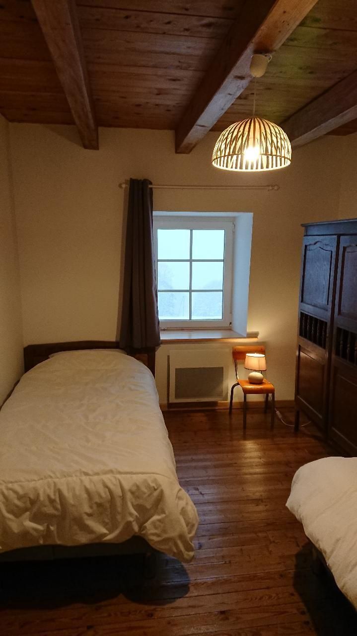 Une chambre à lits simples et son armoire ancienne