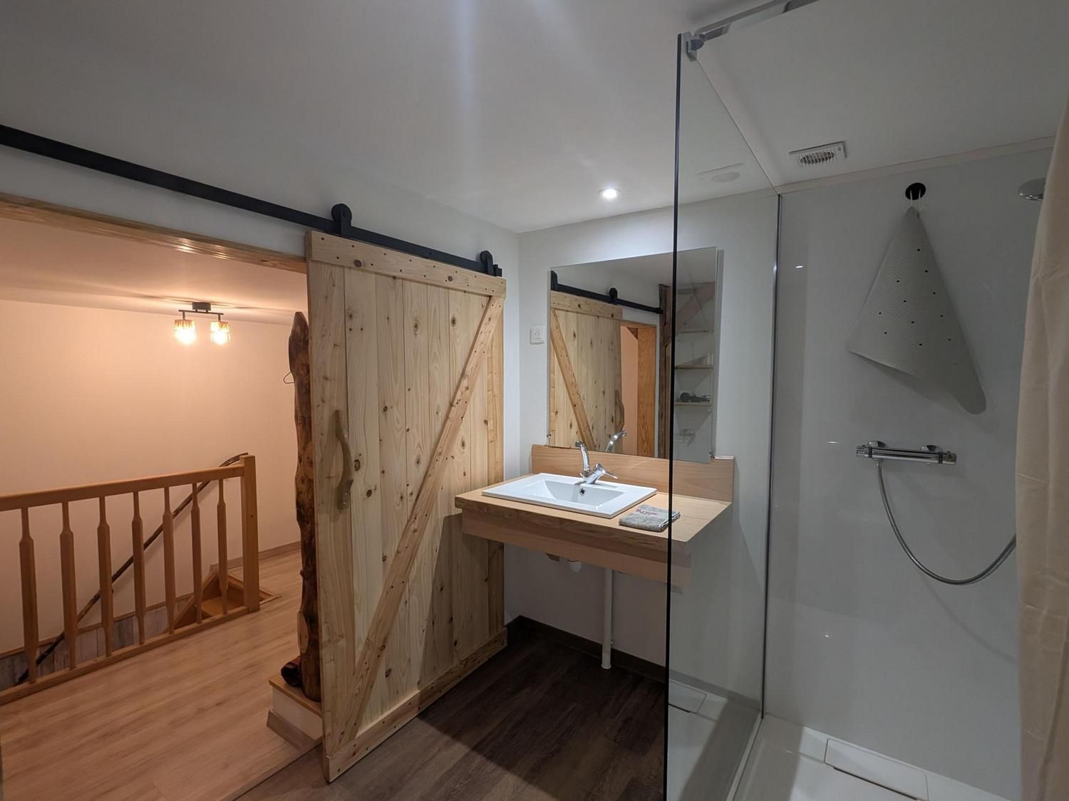 La salle d'eau et sa porte coulissante en bois